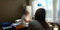 Задержанная за мошенничество женщина и полицейский. Скриншот видео пресс-службы ГУ МВД России по Иркутской области - Irk.Ru